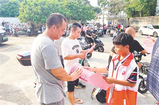 学生志愿者向等候接孩子的家长发放基孔肯雅热防控宣传单。 学生志愿者向等候接孩子的家长发放基孔肯雅热防控宣传单。