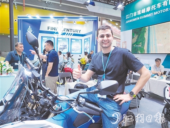 在江门市珠峰摩托车有限公司展位，外国客商前来了解摩托车新品情况，并为产品点赞。张泽彬