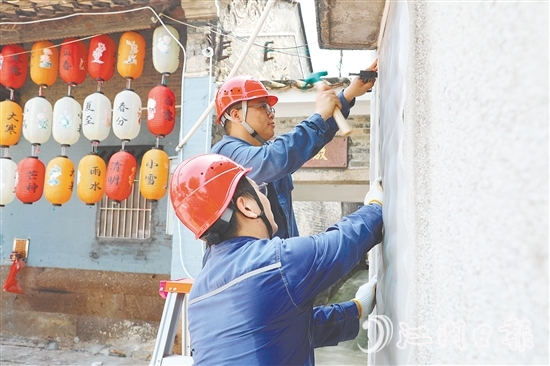 供电人员正在为居民安装纱窗。