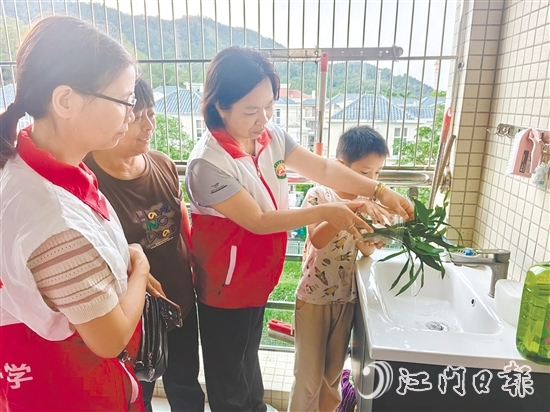 恩平市鳌峰小学党员教师入户指导学生清积水。