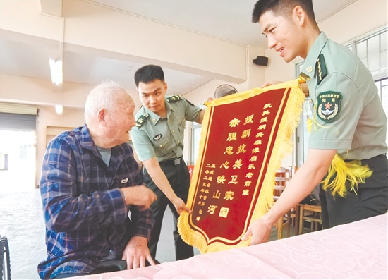 部队官兵代表向谭启乐送上锦旗。 部队官兵代表向谭启乐送上锦旗。