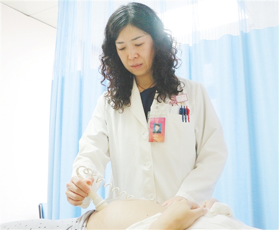产科医生为孕妇检查胎儿状况。