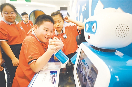 活动中,学生体验和机器人“掰手腕”。 活动中,学生体验和机器人“掰手腕”。
