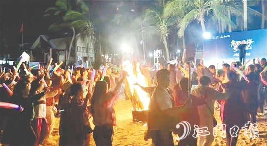 游客在王府洲沙滩上的篝火晚会尽情玩耍。