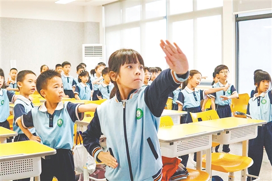 在课桌之间的有限空间中，学生们跟随音乐节奏舒展身体，每一个动作都充满力量。