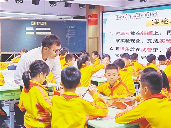 教师指导学生用橡皮筋、铁罐、试管模拟乐器发声。 教师指导学生用橡皮筋、铁罐、试管模拟乐器发声。