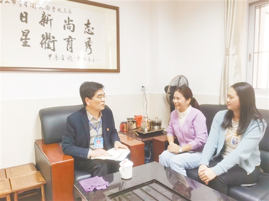 苏金练（左一）与学生家长交流意见。