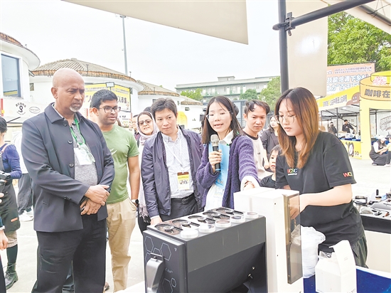 外国友人被活动现场的智能拼豆机所吸引，点赞侨乡江门创新活力。