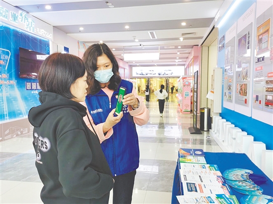 社保志愿者指导市民进行查询操作。