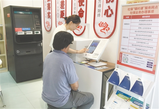 蓬江区杜阮镇上巷村社保“镇村通”工作人员正为群众办理社保业务。