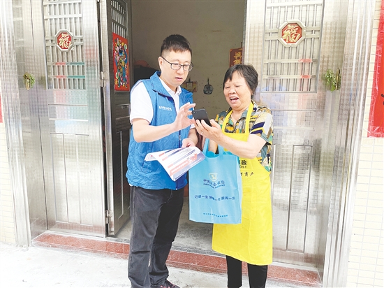 2024年6月恩平市社保志愿者为参保群众提供上门年审服务。