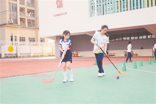 学生体验软式曲棍球。 学生体验软式曲棍球。