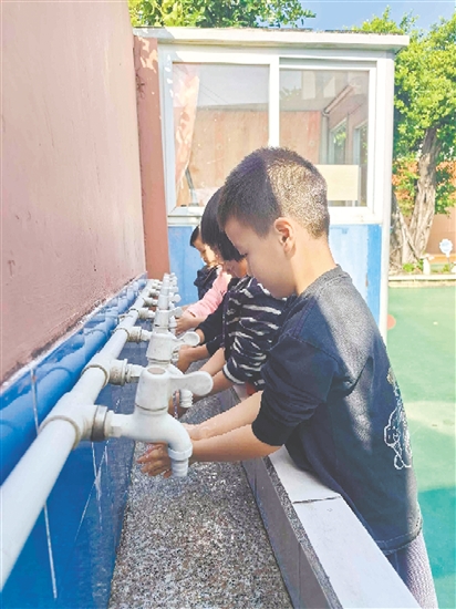 崖门镇田边村幼儿园的孩子们打开洗手池新安装的节水型水龙头，感受那潺潺流出的清澈好水。