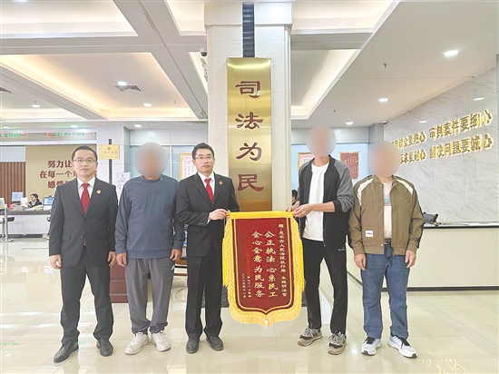 工人领到工资后,为法官团队送来锦旗致谢。 工人领到工资后,为法官团队送来锦旗致谢。