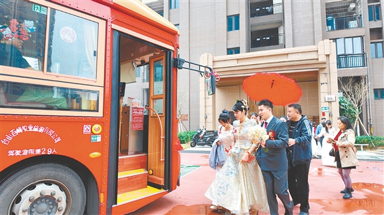 “新宁号”观光巴士的装饰充满浓厚喜庆氛围，车身上密密麻麻写满对新人的祝福语，字里行间满是真诚与美好。