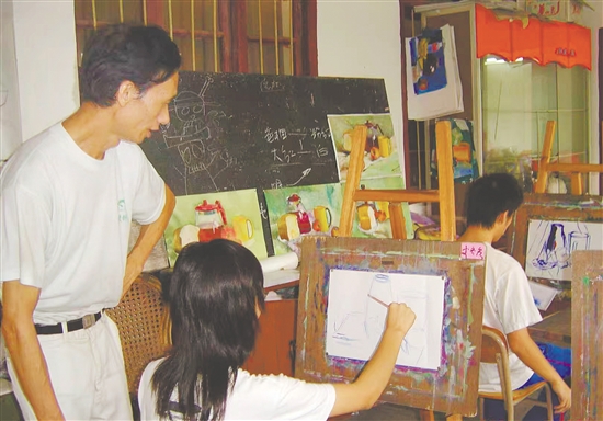 全国青少年宫优秀教师余炳权老师指导学生创作美术作品。