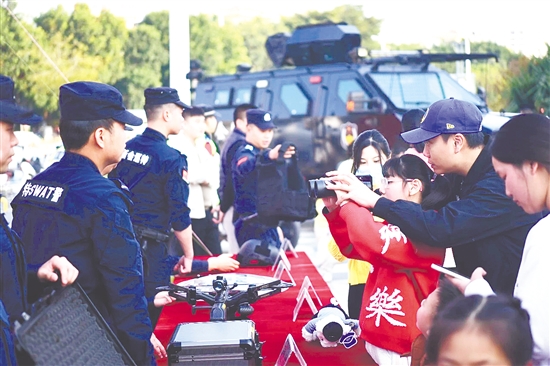 民警为市民讲解警用装备功能与使用场景。 民警为市民讲解警用装备功能与使用场景。