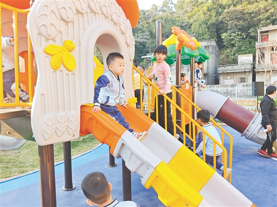 孩子们在新建成的户外活动场地中玩耍。