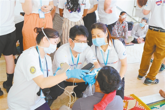 钟景贤参加“柬埔寨光明之行”，为当地眼疾患者进行检查。