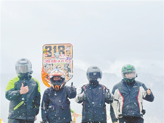 余鸿威（右一）与“旅游搭子”骑摩托车到西藏途中合影留念。