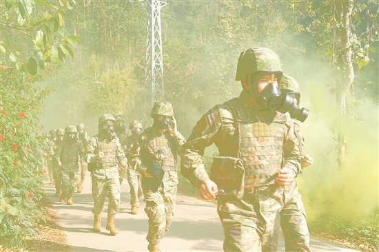 参训队员佩戴防毒面具模拟穿越染毒地带。