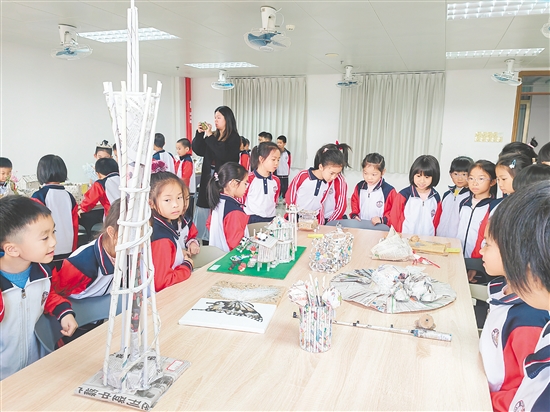 同学们发挥创意，让废旧报纸重获“新生”。