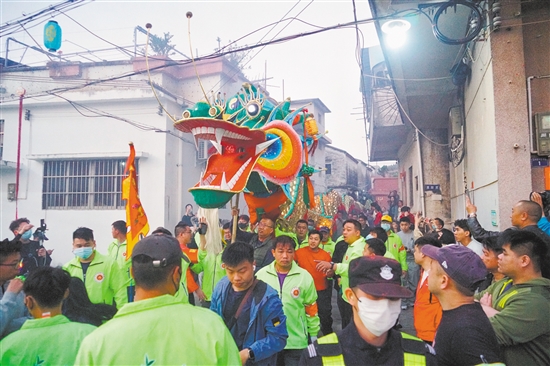 村民们高举金龙，穿街过巷进行巡游。