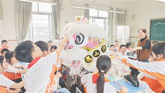 小醒狮伴随着热闹的锣鼓声来到各班教室拜年，学生触摸小醒狮沾沾喜气。