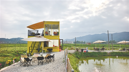 由两个黄色集装箱改造而成的咖啡店“塘边小苑”静立在田野之间。游客们围坐在鱼塘边,喝咖啡、看风景,不时举起手机拍照。 由两个黄色集装箱改造而成的咖啡店“塘边小苑”静立在田野之间。游客们围坐在鱼塘边,喝咖啡、看风景,不时举起手机拍照。