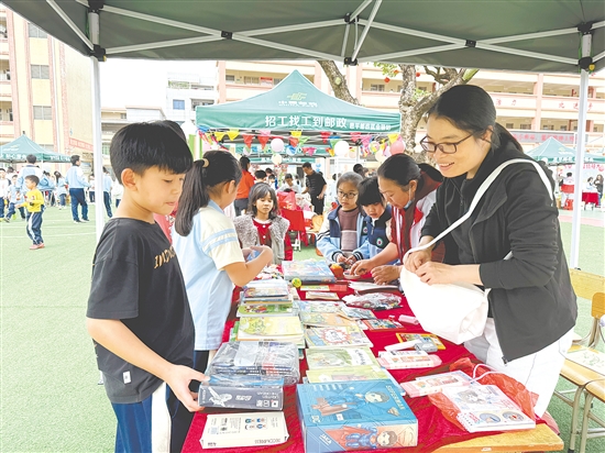 作为“顾客”的学生穿梭在各个摊位之间，认真挑选心仪的物品。