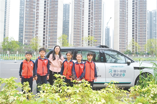 学生走出教室，体验无人驾驶汽车。