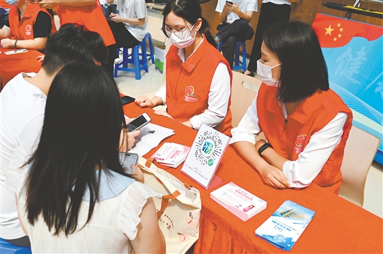 工作人员向市民介绍职工生育保险待遇。 工作人员向市民介绍职工生育保险待遇。