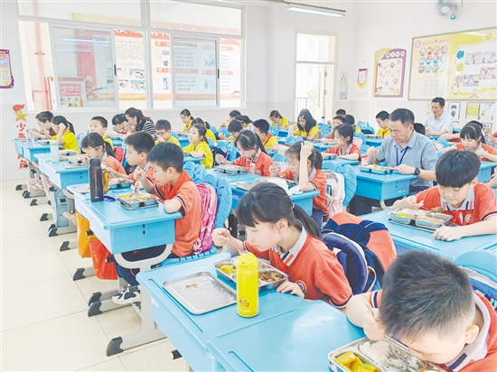 蹲班组成员在教室与学生一起吃午餐。