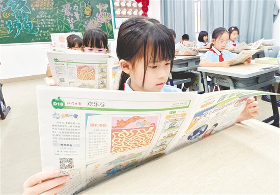 江门广雅学校小学部三年级学生在阅读《江门日报·青苹果》校园专刊。