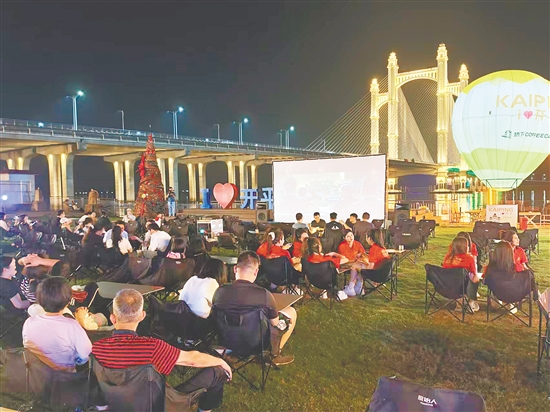 江风轻拂，市民一边喝咖啡，一边看电影。