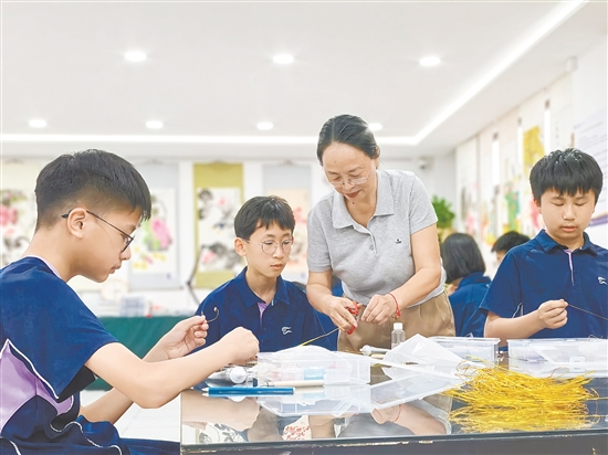 鹤山市七叶树下文祯图书中心负责人李莉教授学生掐丝、粘丝、点蓝等传统技艺。