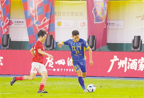 粤超揭幕战，江门队球员正控球寻找突破机会，对手也全力紧逼争抢。