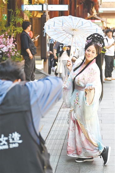 5月5日，外国游客在上海豫园商城内体验古风妆造旅拍。新华社发