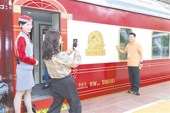 5月19日，长三角地区首趟舒适型旅游列车“长三角之星”从铁路上海西站始发，旅客在登车前拍照留念。新华社发