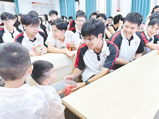 萌娃为高三学子送上水果。