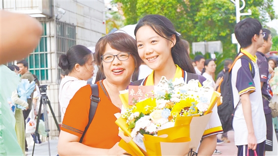 考生捧花与家长合影。