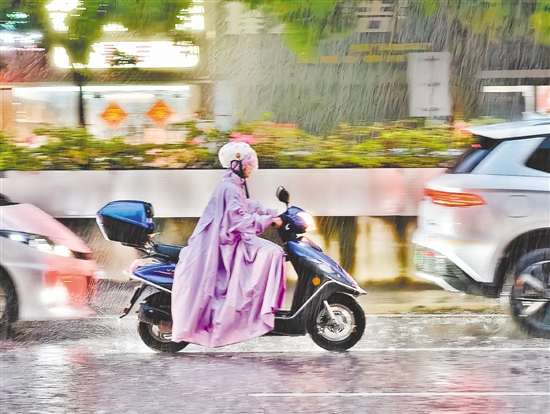 连日来，江门遭遇强降雨天气。图为市民冒雨驾驶摩托车途经蓬江区东华一路。