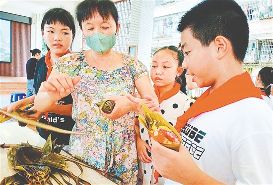幕村小学的家长老师化身民俗导师，手把手示范包裹粽子。