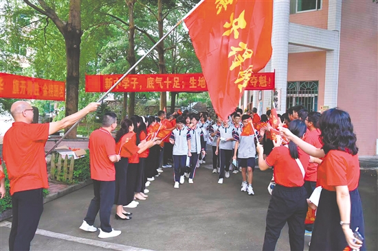 送考老师身着红色上衣，为步入考场的考生加油鼓劲。