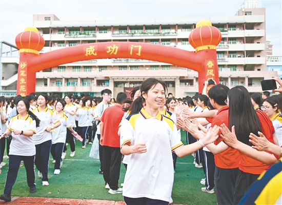 学生穿过“成功门”，与老师击掌。