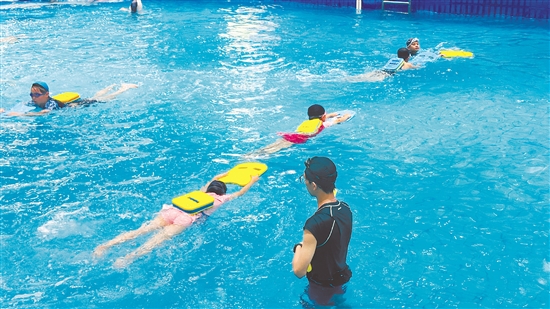 在浅水教学区，不少学生在教练的指导下反复练习游泳基础动作。