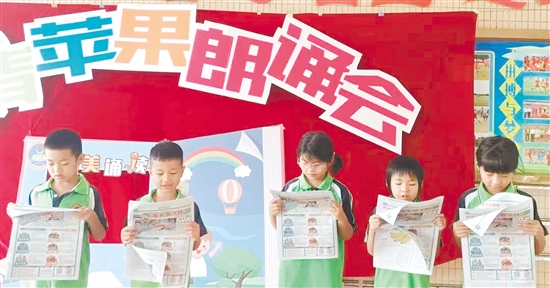 孩子们朗读《侨乡教育·青苹果》校园专刊上的文章，品读江门侨乡风物。