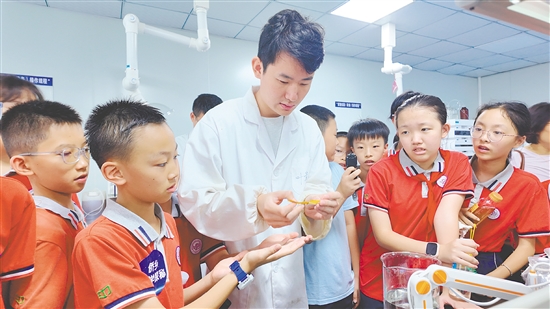 学生在导师的帮助下操作科学实验。 学生在导师的帮助下操作科学实验。