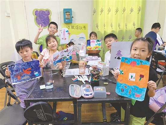 圭峰会城总工会职工子女暑假托管班的孩子们展示自己的画作。