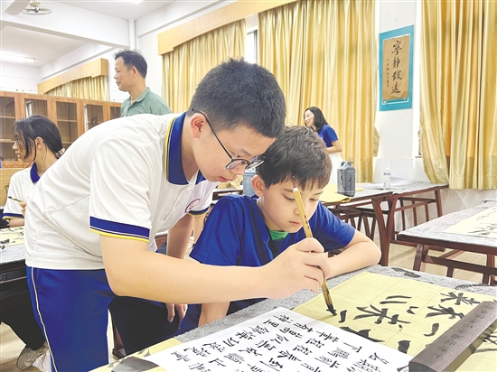 鹤山中学生教法国华裔青少年写毛笔字。